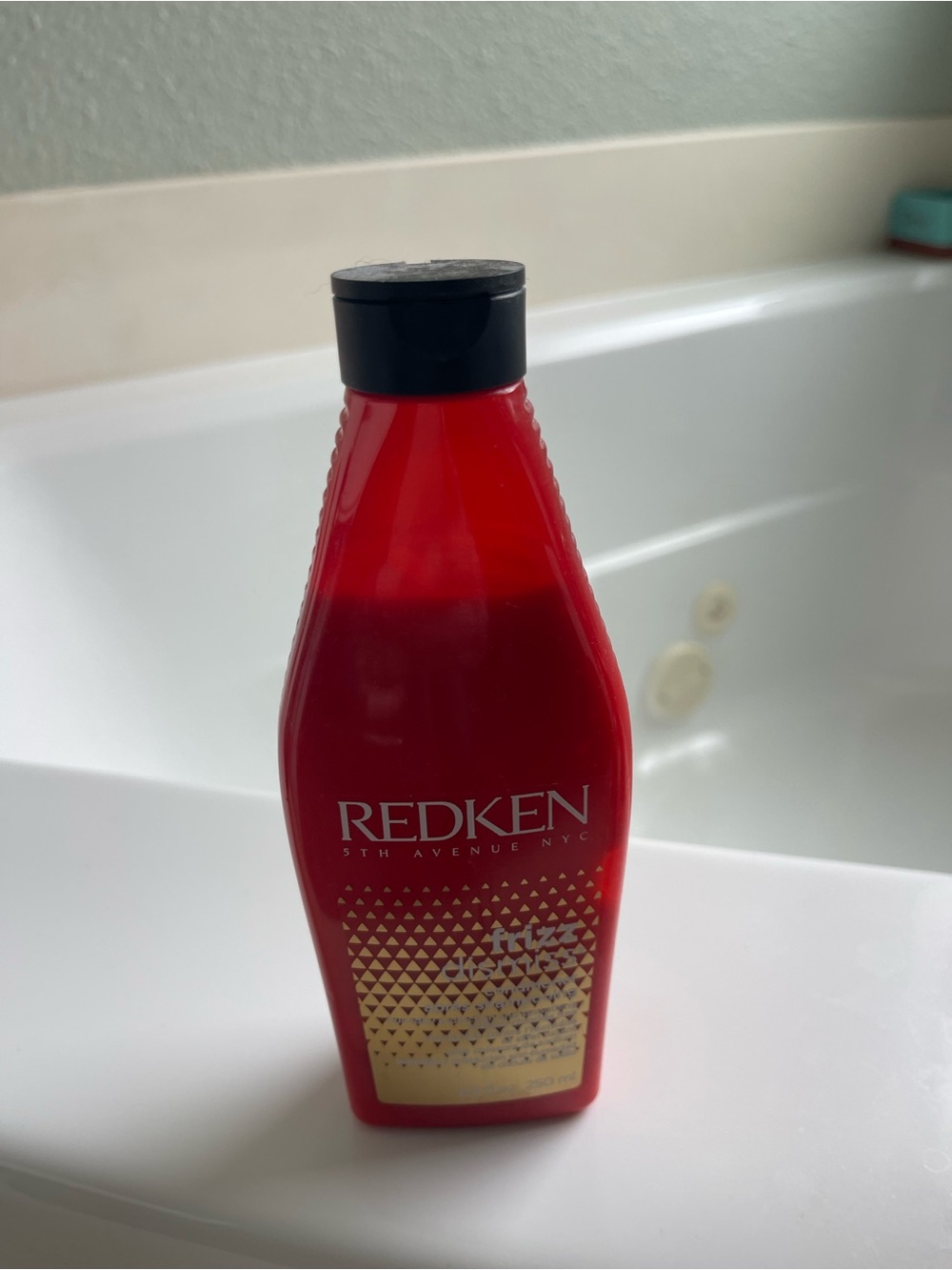 Redken Haircare Bottle in Red with Black Cap and Gold Accent